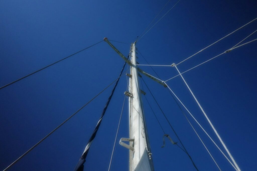 Sailboat mast and standing rigging against a clear blue sky